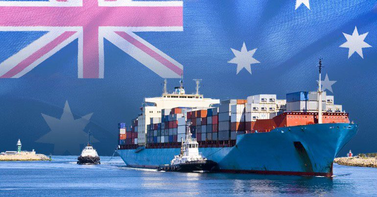 A composite image of a blue container ship guided by tugboats in a harbor, set against a large waving Australian flag, symbolizing Australia shipping.